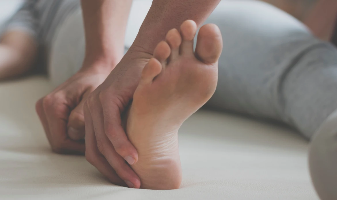 person holding his foot in pain